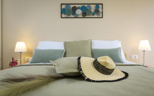 a straw hat sitting on top of a bed at Lavica Seaside Apartments, Podstrana in Podstrana