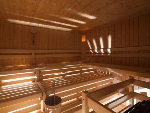 an empty sauna with wood paneling and a bucket at Runcac Apt Pla in San Vigilio Di Marebbe