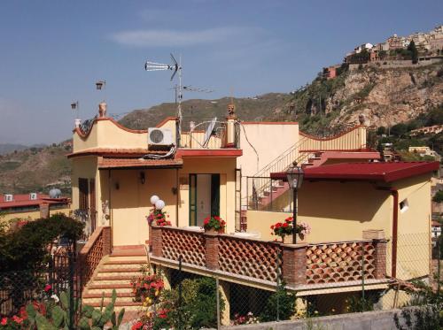 a house with a balcony with flowers on it at B&B U Palmentu in Taormina