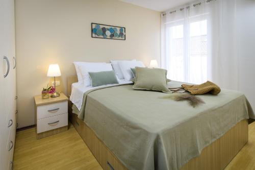 a bedroom with a large bed with a window at Lavica Seaside Apartments, Podstrana in Podstrana