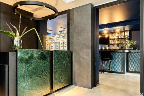 a bar with a green counter in a room at Hotel Liberte 33 BW Premier Collection in Poznań