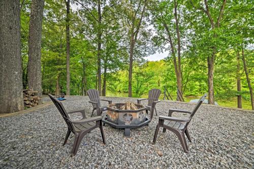 a group of chairs around a fire pit in the woods at Lake Barkley Home Private Dock, Kayaks, Fire Pit! in Cadiz