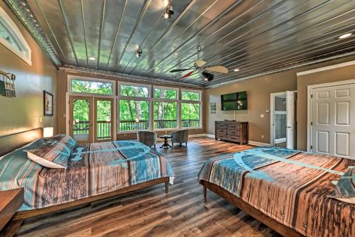 2 camas num quarto com pisos e janelas em madeira em Lake Barkley Home Private Dock, Kayaks, Fire Pit! em Cadiz