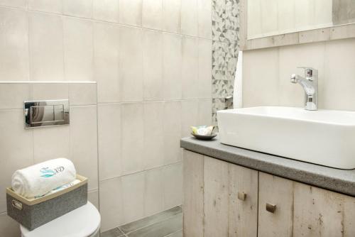 un bagno bianco con lavandino e WC di XD Central Apartments a Ierissós