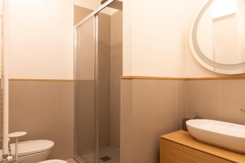 a bathroom with a sink and a toilet and a mirror at Palazzo dei Ciompi Suites in Florence