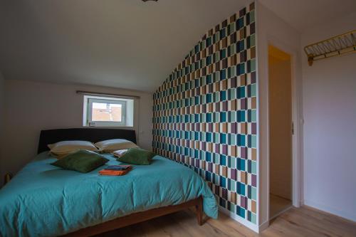 a bedroom with a bed with a wall with colorful squares at Emilie une nuit - 3 chambres au 2e étage - maison avec chats in Vandières