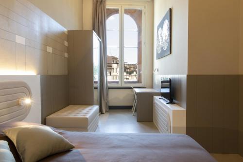 a hotel room with a bed and a window at Palazzo dei Ciompi Suites in Florence