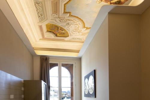 a coffered ceiling in a hallway with a window at Palazzo dei Ciompi Suites in Florence