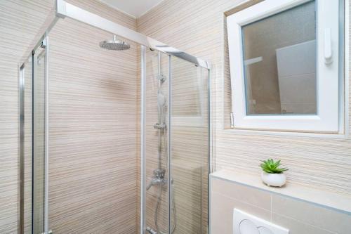 a bathroom with a shower with a glass door at Corallium Precious in Pomena