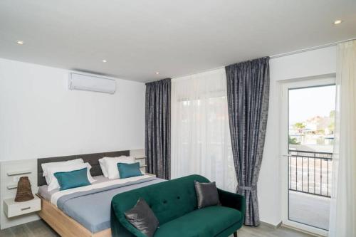 a bedroom with a bed and a green couch at Corallium Precious in Pomena