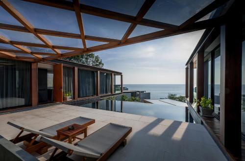 a house with a view of the ocean on the balcony at The Naka Phuket, a member of Design Hotels in Kamala Beach
