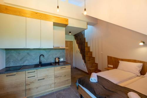 a kitchen with a bed and a sink in a room at Aparthotel Pod Stokiem z sauną i jacuzzi - szczyrkapartamenty in Szczyrk