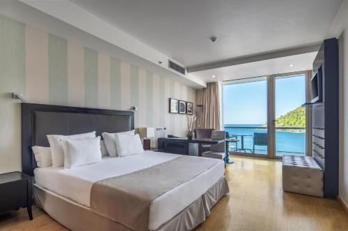 a bedroom with a bed with a view of the ocean at Angra Marina Hotel in Angra do Heroísmo