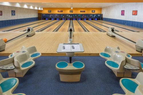a bowling alley with lanes and chairs in a gym at SOWELL Family Le Vallon in Grospierres