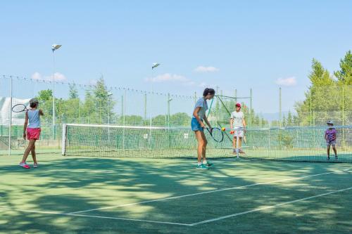 a group of people playing tennis on a tennis court at SOWELL Family Le Vallon in Grospierres
