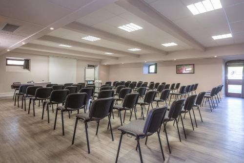 a room with rows of chairs and a whiteboard at SOWELL Family Le Vallon in Grospierres