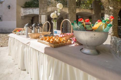 a long table with baskets of fruit and drinks on it at SOWELL Family Le Vallon in Grospierres