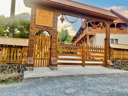 a wooden gate in front of a building at Floare de Maramures 1 in Vadu Izei