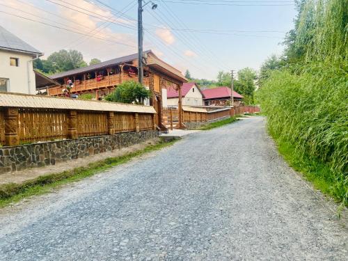 a dirt road in a village with a building at Floare de Maramures 1 in Vadu Izei