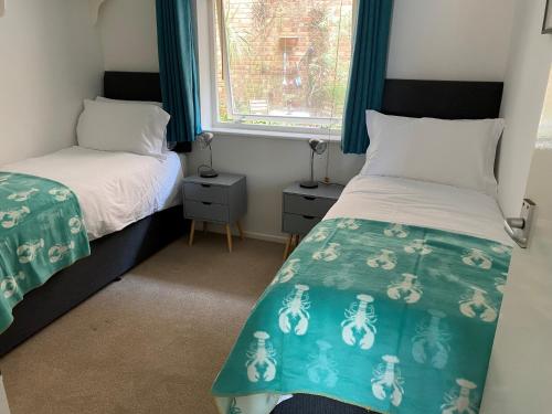 1 dormitorio con 2 camas y ventana en Vitamin Sea with a Sea View and Parking, en Lyme Regis