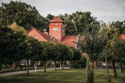 ein Gebäude im Hintergrund mit Bäumen im Vordergrund in der Unterkunft Waldhotel Eiche in Burg