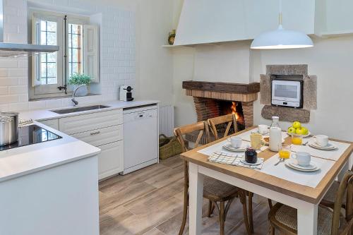 a kitchen with a table and a fireplace at Can Cristus in Monells