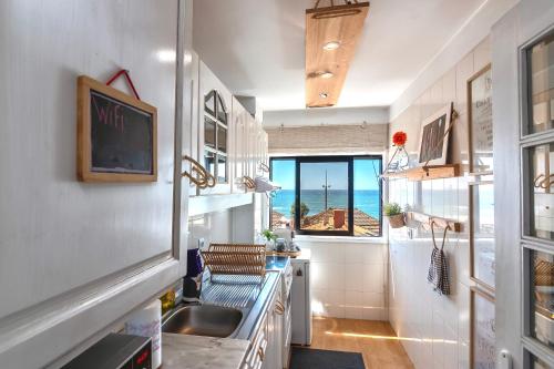 a kitchen with a sink and a view of the ocean at Espinho Guesthouse - Sea View Apartment in Espinho