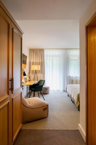 a hotel room with a bed and a desk at Waldhotel Eiche in Burg