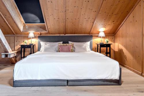 a bedroom with a large white bed with two tables at Villa Zollhaus Bed & Breakfast in Türkheim