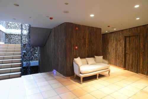 a living room with a white chair and wooden walls at Hotel Rural Quercus Tierra in Garganta de los Montes