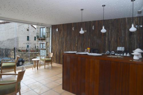 a kitchen with a bar with chairs and a balcony at Hotel Rural Quercus Tierra in Garganta de los Montes