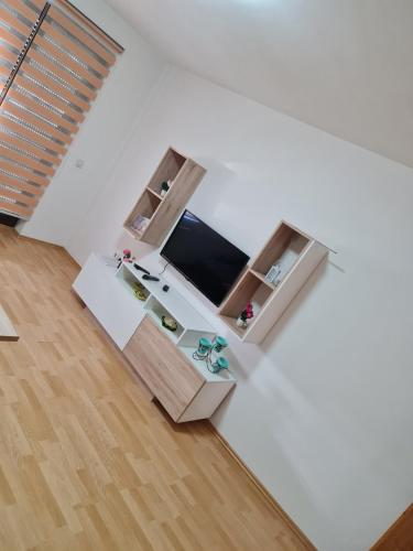 APARTMANI SK في برتشكو: غرفة بيضاء مع مكتب وتلفزيون