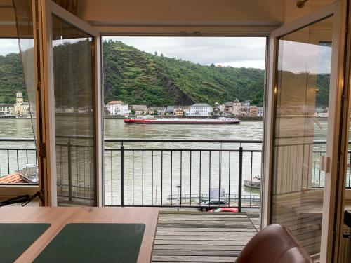 a balcony with a view of a boat on the river at Ferienwohnung "drei Burgen Blick" in Sankt Goar