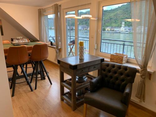 ザンクト・ゴアーにあるFerienwohnung "drei Burgen Blick"のリビングルーム(テーブル付)、窓付きのキッチンが備わります。