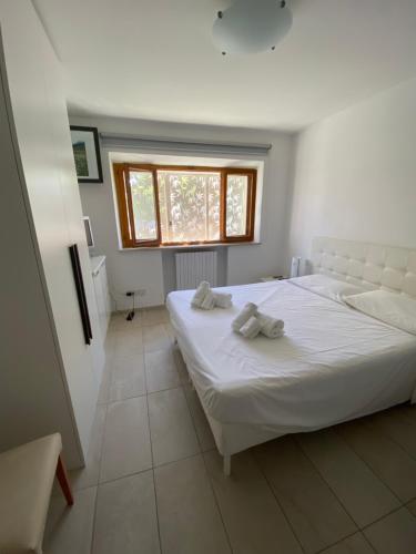 ein Schlafzimmer mit einem weißen Bett und einem Fenster in der Unterkunft Antistress Affittacamere in Osimo