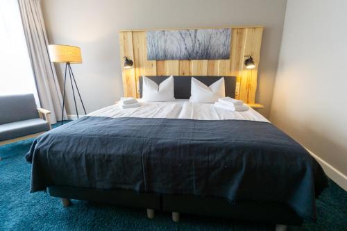 a bedroom with a large bed with a blue carpet at Waldhotel Eiche in Burg