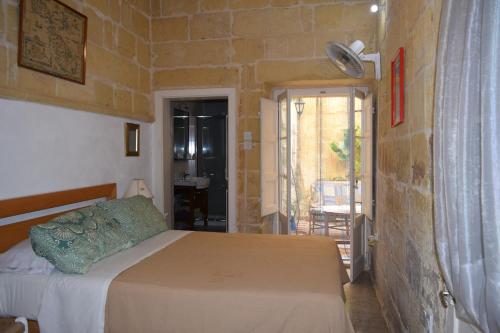 a bedroom with a bed and a brick wall at Maria Townhouse Heart of Victoria B&B in Victoria
