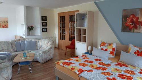 uma sala de estar com uma cama e um sofá em Ferienwohnung König Niedergurig bei Bautzen em Niedergurig