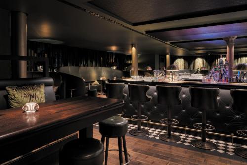 a bar with black leather seats and a wooden table at TORTUE Hamburg in Hamburg