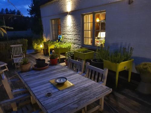 a wooden table and chairs in front of a house at Ten-Briele in Bornem