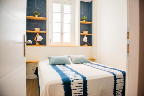 una camera con letto, finestra e scaffali di La Maison des Vendangeurs en Ville a Narbonne