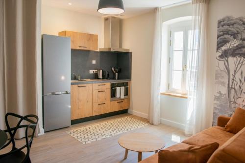 - une cuisine avec un réfrigérateur et une table dans la chambre dans l'établissement La Maison des Vendangeurs en Ville, à Narbonne