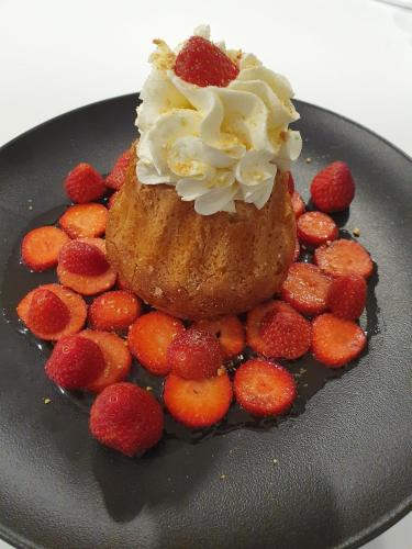 a dessert with whipped cream and strawberries on a plate at Pavillon des Millésimes, Piscine & SPA in Lussac