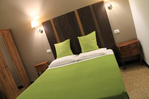 a bedroom with a green bed with a wooden headboard at Hotel Bologna in Genova