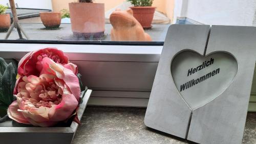 a box with a heart on it next to a flower at Hotel Merlin Garni in Cologne
