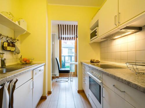 een keuken met gele muren en een aanrecht bij Kaiservillen Heringsdorf - Ferienwohnung mit 1 Schlafzimmer und Terrasse D101 in Heringsdorf