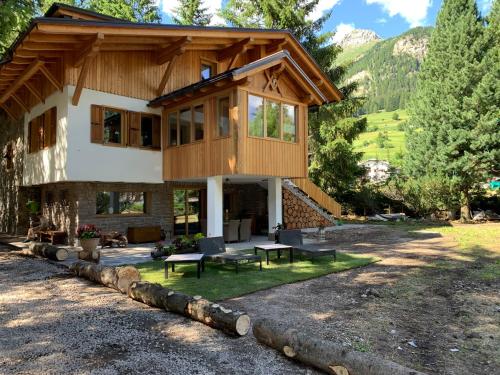 a house in the mountains with a patio at Chalet degli Abeti by AMA Val di Fassa in Campitello di Fassa