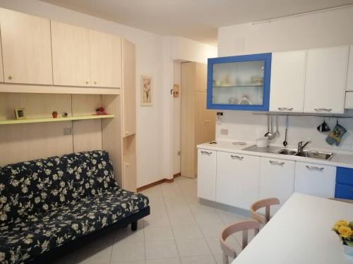 ein Wohnzimmer mit einem Sofa und einer Küche in der Unterkunft Val di Luce Home in Abetone