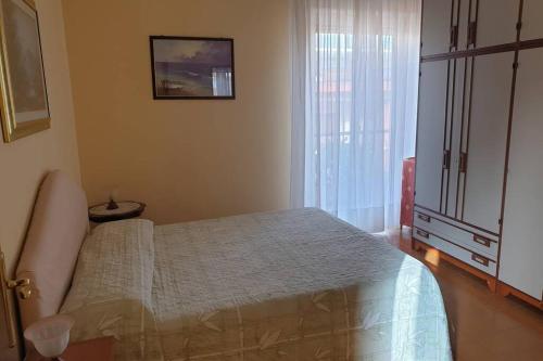 um quarto com uma cama e uma janela em Casa vacanze Ada em Capo dʼOrlando