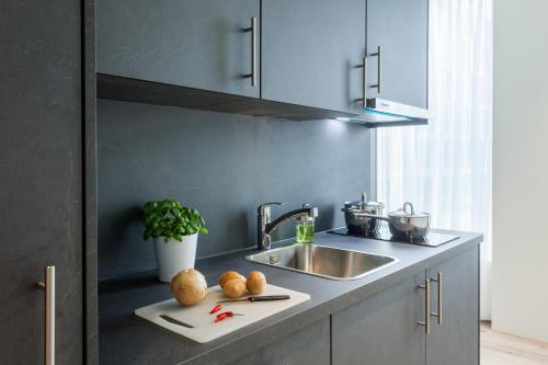 a kitchen with a sink and a counter with bread at Centurion Swiss Quality Towerhotel Windisch in Brugg